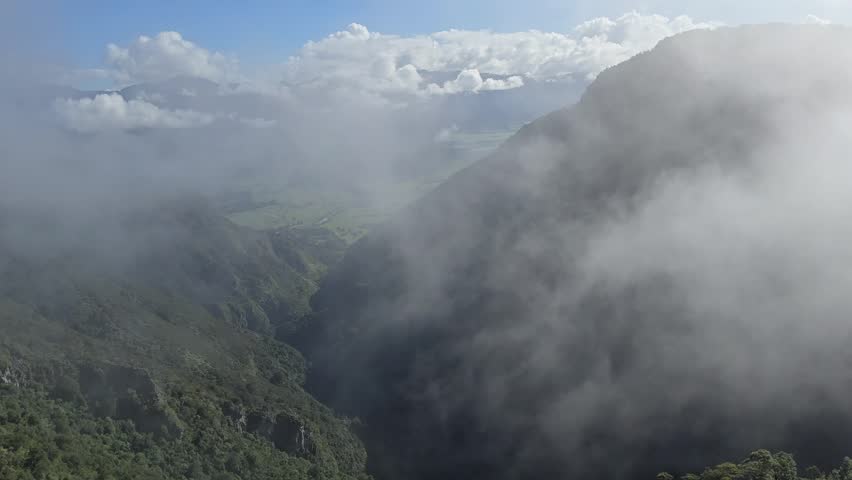 The fog slowly ascends the mountain valley in Abel Tasman National Park, New Zealand
