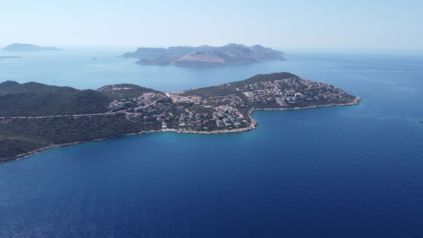 Aerial drone approach to a luxury peninsula with upscale villas in Kas, Turkey. Premium seaside lifestyle, luxury real estate and elite travel destination concept. Ungraded, DLog