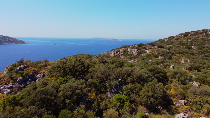 Aerial drone approach to a luxury peninsula with upscale villas in Kas, Turkey. Premium seaside lifestyle, luxury real estate and elite travel destination concept.