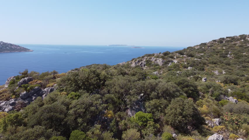 Aerial drone approach to a luxury peninsula with upscale villas in Kas, Turkey. Premium seaside lifestyle, luxury real estate and elite travel destination concept. Ungraded, DLog