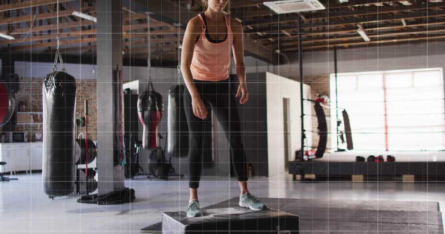 Woman starting on plyo box doing step-ups and jumps in gym, showing teal graphs building power. Fitness, training, athlete, studio, cardio, endurance, focus