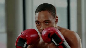 Male boxer boxing in studio in red gloves continuing punches driving sports charts overlaying torso. Athlete, focus, determination, sweat, gym, urban, daylight - Powered by Shutterstock - Get 15% off with code: PIKWIZARD15