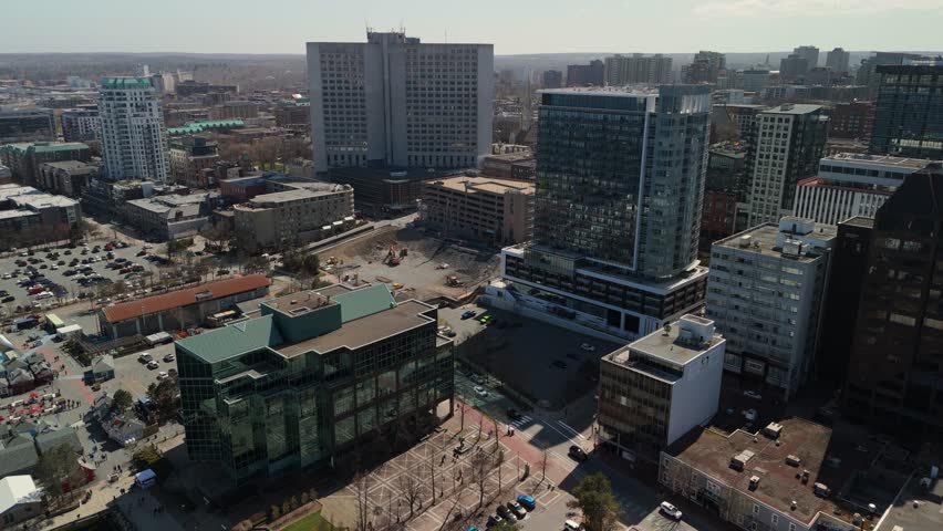 Aerial Footage Shows Modern Halifax Nova Scotia Canada With Tall Skyscrapers A Busy Summer Waterfront Yachts In The Harbor And Tourists Walking Along The Sunny City Promenade Creating A Vibrant Scene