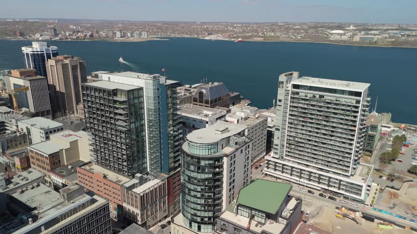 Aerial View Shows Halifax Nova Scotia Canada With Modern City Towers A Busy Waterfront Marina Boats And Visitors Enjoying The Sunny Coastal Boardwalk During A Beautiful Summer Day