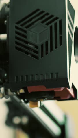 FDM filament 3d printer starts extruding hot plastic, close-up, vertical video