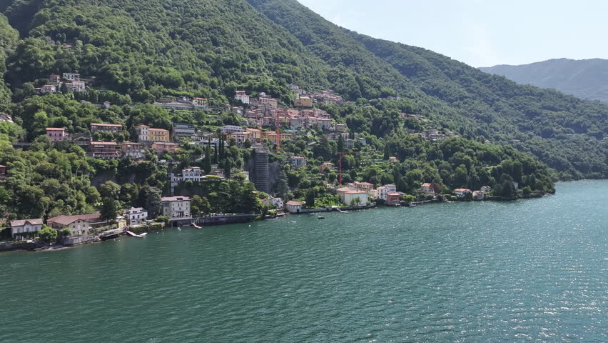 wide lakeside village with emerald water and rolling hills, small harbor, scattered houses and quiet shoreline offering tranquil