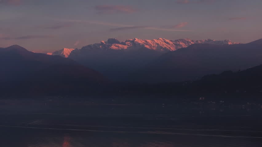 alpenglow illuminating snowcapped mountain peaks pink light kisses crests and glaciers, clear cold air, long shadows