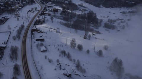 Drone Turning over Snowy Town Dusk