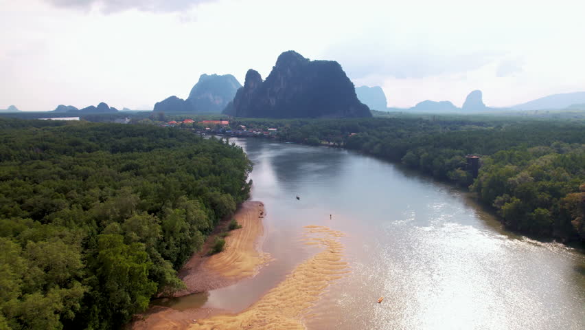 Aerial flight over a river surrounded by a mangrove forest in Thailand