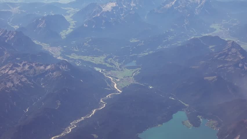 Mountain landscape with lakes and settlements from an airplane window.