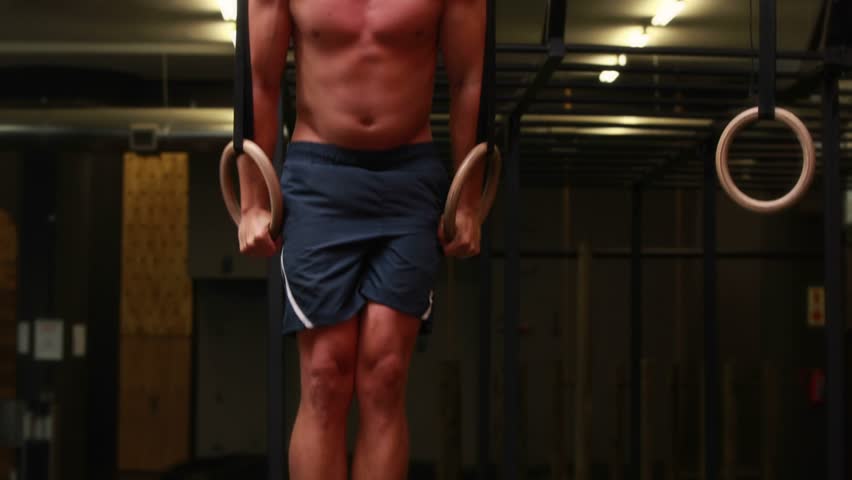 Man holding rings holding support, Data Terminal overlay fading in showing fitness data over chest. Gym, strength, athlete, focus, core, rig, hud