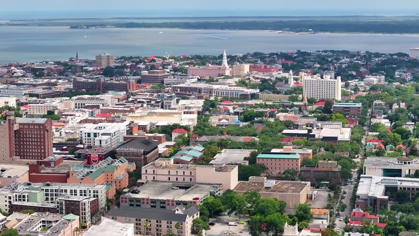 Aerial view of Charleston, South Carolina skyline and cityscape with buildings, parks, church steeples and the waterfront and coastal lowcountry landscape - 4K Drone