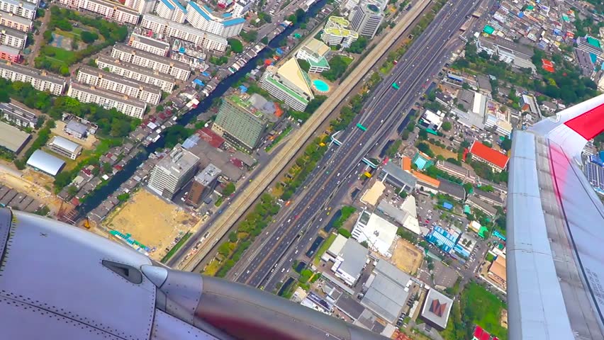 Flight over city town airport with panorama panoramic view from the airplane cityscape skyline clouds and blue sky horizon in Don Mueang Bangkok Central Thailand in Southeastasia Asia.
