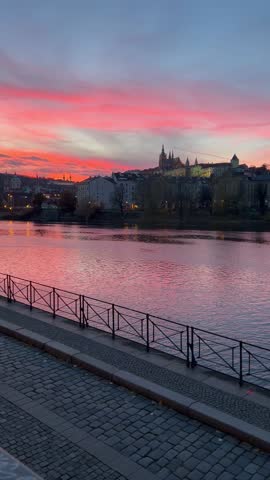 A view from the embankment on the historical buildings of Lesser town (Mala Strana) across the river during colourful sunset. Prague, Czech Republic 
