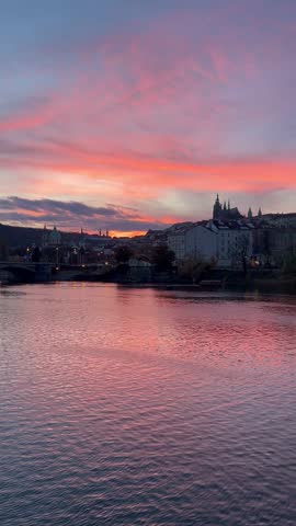 Colourful cloudy sunset sky above the Vltava river and Saint Vitus cathedral on skyline. Prague, Czech Republic