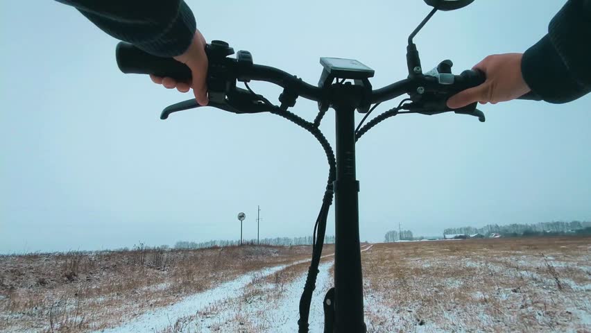 A first-person view of an electric bike in winter. POV. Horizontal video