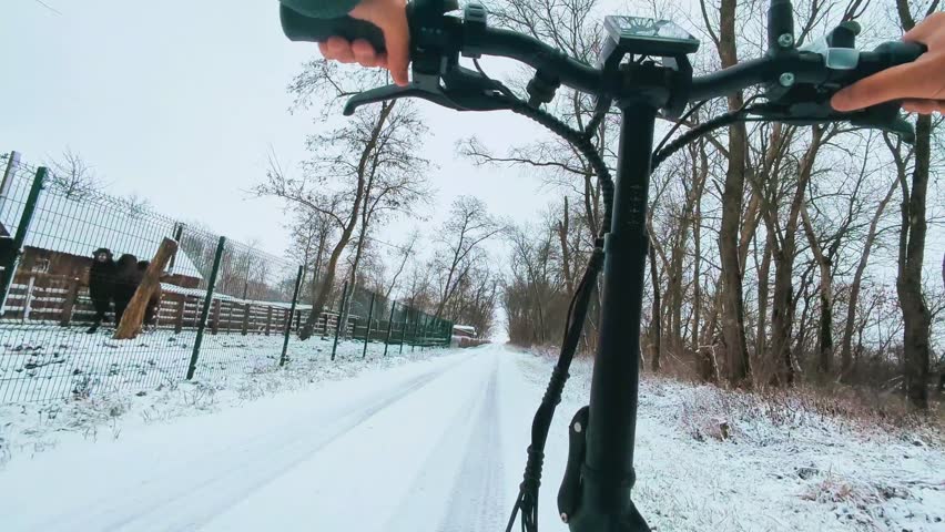 A first-person view of an electric bike in winter. POV. Horizontal video