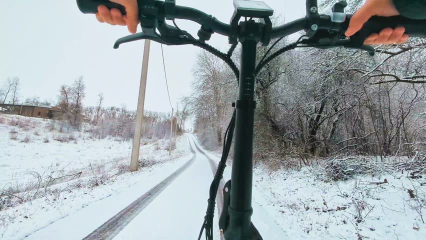 A first-person view of an electric bike in winter. POV. Horizontal video