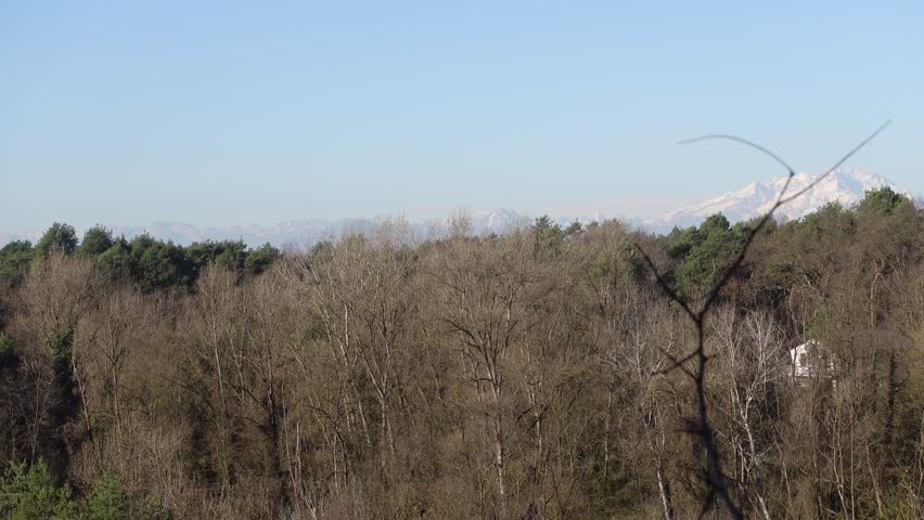 An aircraft flying far away during takeoff, captured against a scenic Himalayan landscape.