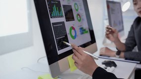 Close up of two business analysts discussing and pointing at financial statistics and graphs on a desktop computer during a team meeting - Powered by Shutterstock - Get 15% off with code: PIKWIZARD15