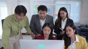 Diverse group of young asian business professionals collaborating on a computer, discussing ideas and planning strategy in a modern office - Powered by Shutterstock - Get 15% off with code: PIKWIZARD15