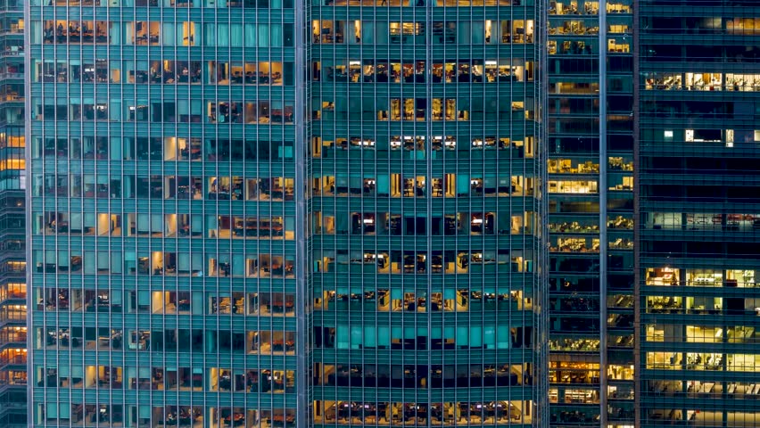 Sliced time lapse day to night view of an illuminated office building with business workers movement, urban concept for white collar business and finance