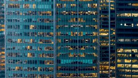 Sliced time lapse day to night view of an illuminated office building with business workers movement, urban concept for white collar business and finance - Powered by Shutterstock - Get 15% off with code: PIKWIZARD15