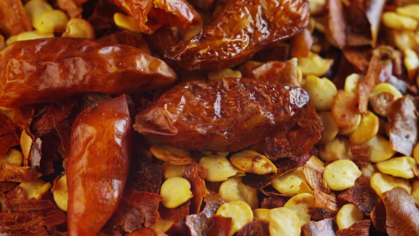 Macro shot of a dried whole chili and chopped chili, highlighting its spiciness, antioxidant properties, healing benefits, and Italian culinary style concept.