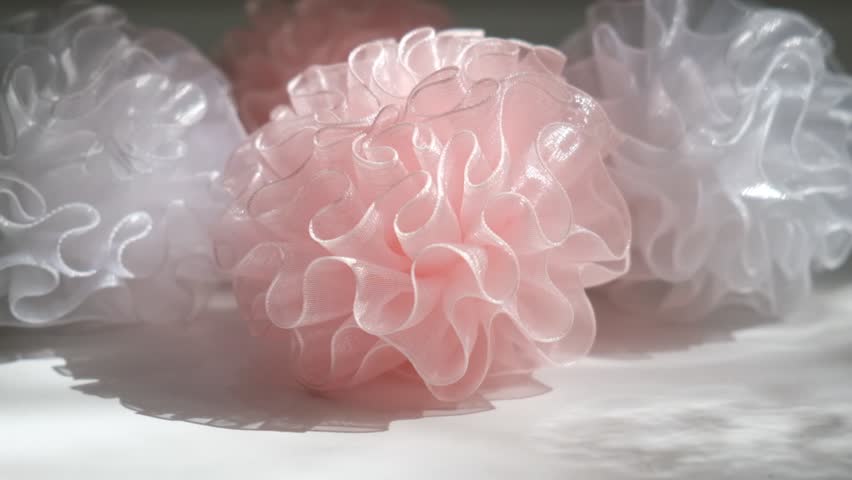Interlacing flounces of the finest pink silk pleats of textured fabric like a rose flower, light pink fabric bows for decoration stage costume