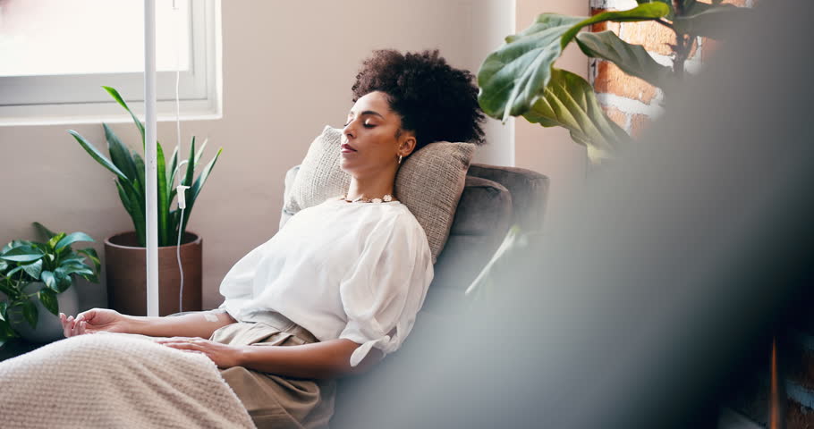 Woman, relax and wellness in clinic with iv drip for healthcare, detox and hydration benefits. Person, sleeping and rest in medical center with intravenous fluid for nutrients, vitamins and minerals.