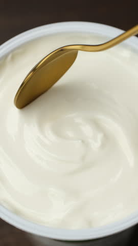 Fresh sour cream or greek yogurt scoop with spoon, close up