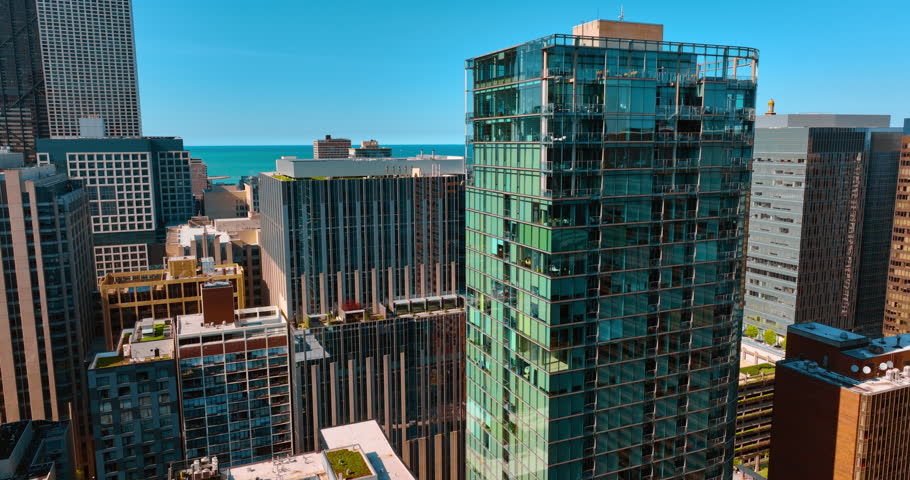 Approaching a high-rise glass building in the downtown of Chicago, Illinois, USA. Lake Michigan at backdrop.
