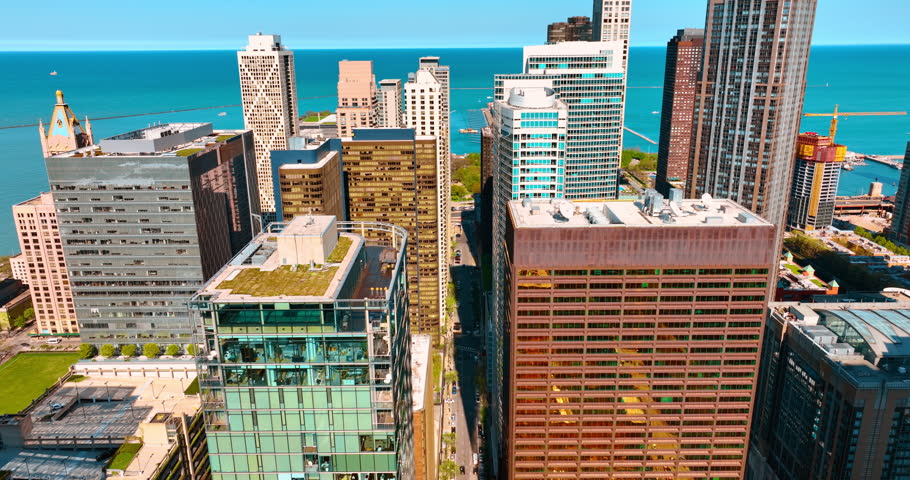 Approaching the waterscape of Lake Michigan. Flying above the street of Chicago, Illinois, USA. Aerial view.
