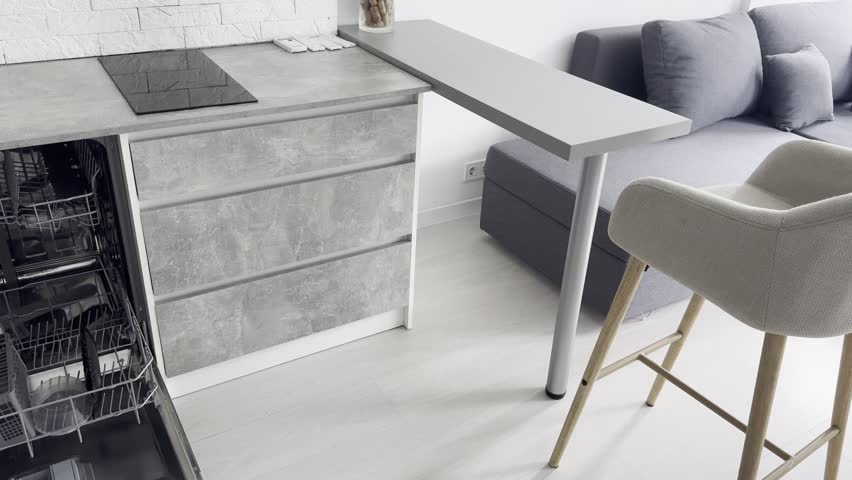 Open clean empty dishwasher in kitchen. Home appliance