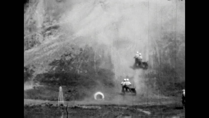 Motorcycle racing competition. Motorcyclists competing in dusty sidecar hill climb race. Extreme sports on dusty desert streets. Dangerous show. Old film. Archival retro 1960s. Vintage archive.