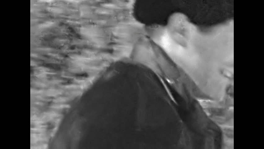 Man skiing down snowy slope, falling, back view. Skier jump off ramp falling in snow. Funny moment of winter sport. Hilarious adventure in ski resort. Old film. Archival retro 1960s. Vintage archive