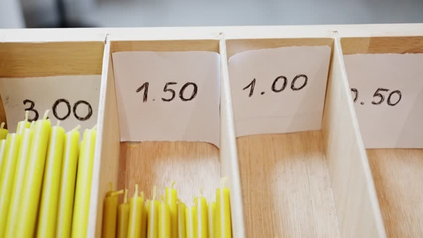 Wooden Shelf With Price Tags, Shelf Showcasing Colored Candles With Handwritten Prices For Shoppers, Display Of Various Taper Candles In Compartments With Handwritten Price Tags For Customers