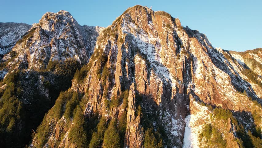 Aerial shot of a mountain cliff and snow