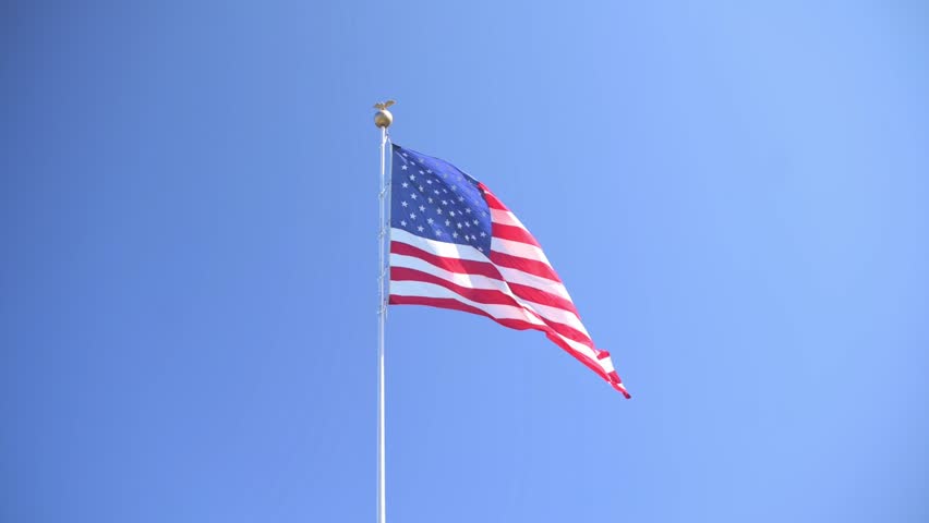 Flag flutters under blue sky, National flag gracefully waves beneath vibrant azure sky chances, American banner flutters peacefully under bright blue sky during steady breeze