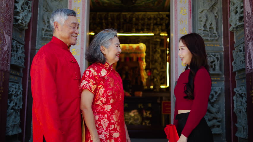 A special moment unfolds as a daughter surprises her parents with thoughtful gifts at a colorful Chinese temple during Lunar New Year, filling the air with love and happiness.