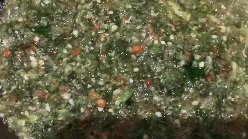 Close-up of making sambal hijau, a popular Indonesian green chili sauce, highlighting frying process, fresh ingredients, and authentic cooking method. Ideal for food preparation, traditional cuisine.