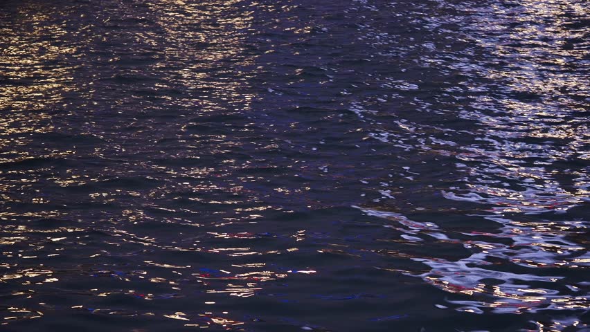 Calm water reflecting city lights during a nighttime stroll