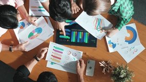 Top down aerial view of smart business people analyze data together at meeting. Group of business team working together and looking at financial chart at tablet placed on meeting table. Convocation. - Powered by Shutterstock - Get 15% off with code: PIKWIZARD15