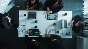 Top down aerial view of manager standing and present marketing plan to skilled investor. Diverse business team working together to analyze financial statistic graph at meeting table. Directorate. - Powered by Shutterstock - Get 15% off with code: PIKWIZARD15