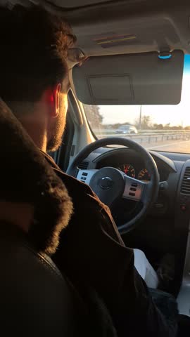 Driving commute highway, man drives car during sunset golden hour on an evening road trip.