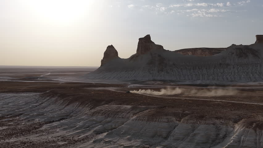 Off-road vehicle driving through the vast ustyurt plateau at sunset