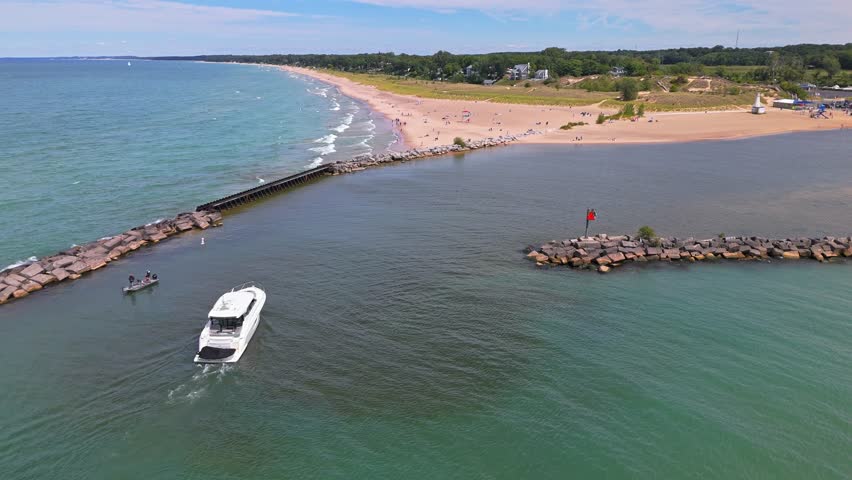 Low aerial flyover of New Buffalo Beach, Michigan, with stunning views over Lake Michigan and the peaceful shoreline on a sunny summer day