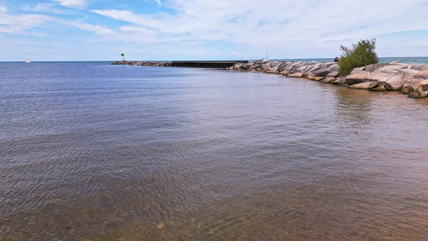 Low aerial flyover of New Buffalo Beach, Michigan, with stunning views over Lake Michigan and the peaceful shoreline on a sunny summer day