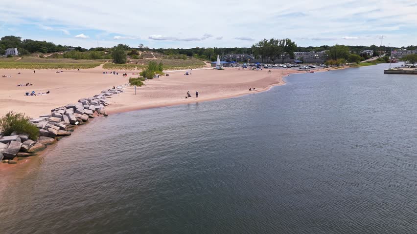 Aerial pull out shot of New Buffalo Beach, Michigan, with stunning views over Lake Michigan and the peaceful shoreline on a sunny summer day