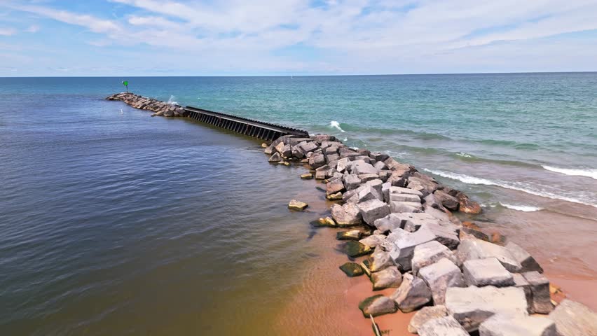 Low aerial flyover of New Buffalo Beach, Michigan, with stunning views over Lake Michigan and the peaceful shoreline on a sunny summer day